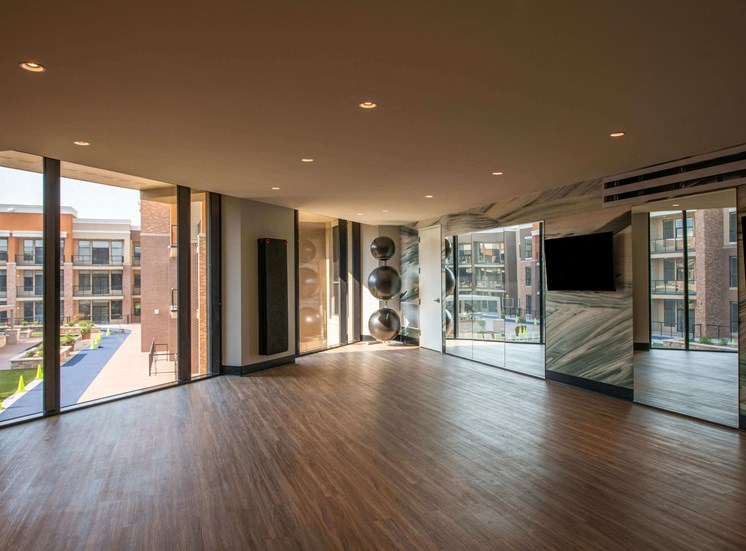 studio space with hardwood floors, ceiling to floor mirrors and windows, and some workout equipment